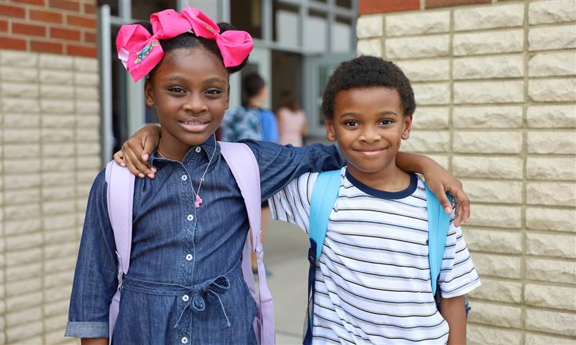 Two students smile